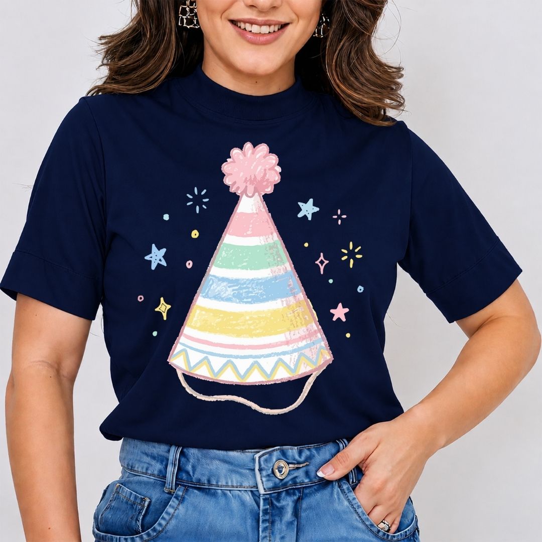 A woman wearing a dark navy mock-neck top featuring a pastel-striped party hat illustration surrounded by small stars and sparkles.
