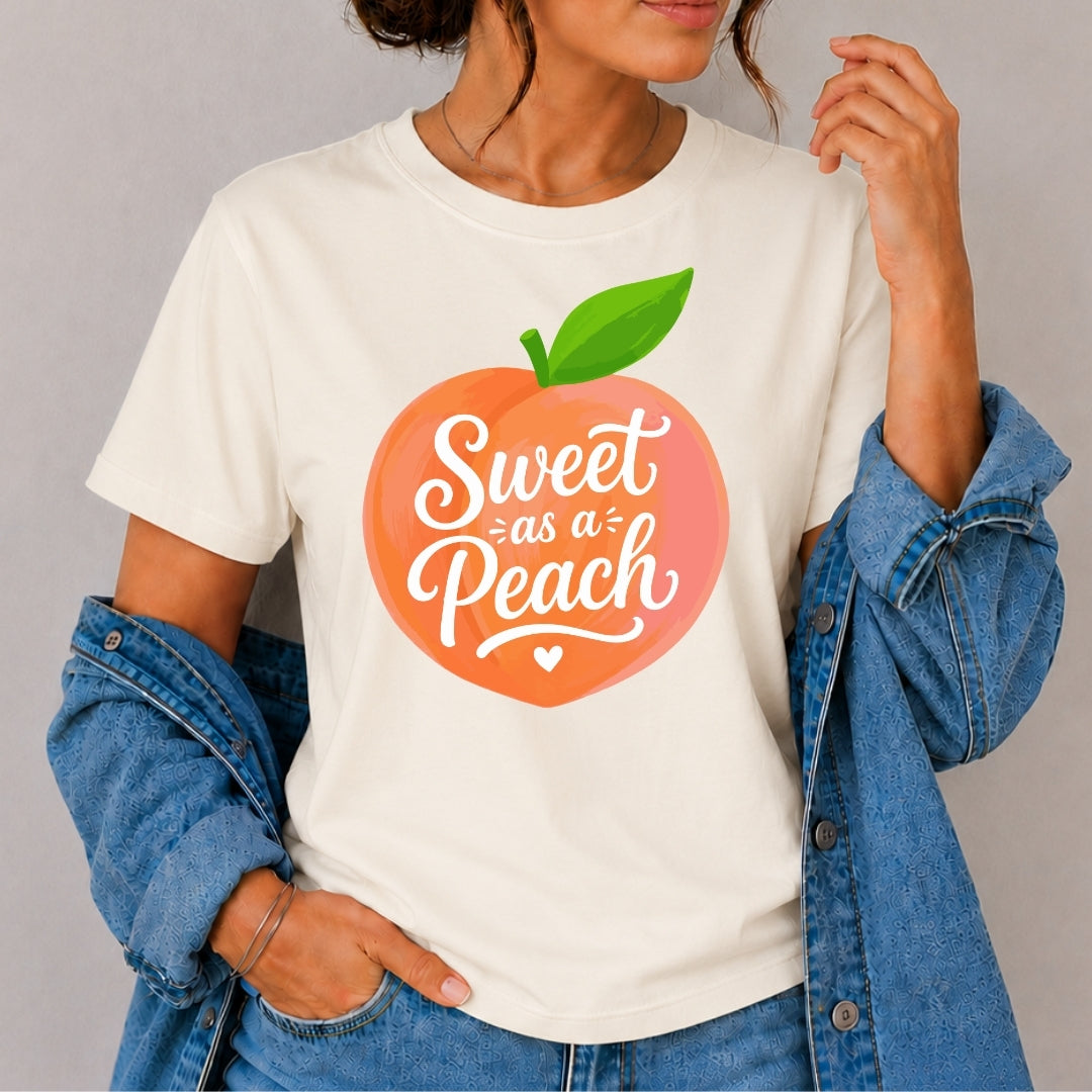 Person wearing a white t-shirt with a peach graphic and 'Sweet as a Peach' text.