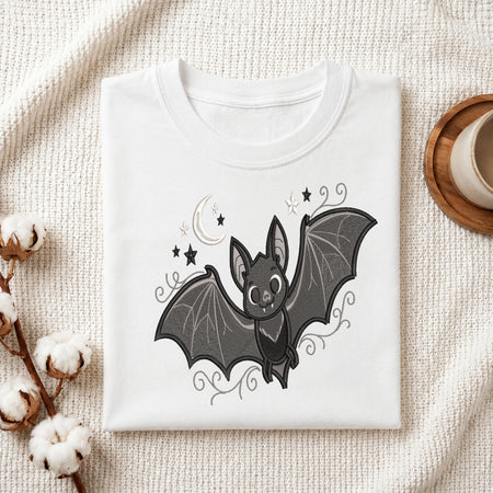 White folded t-shirt featuring a cute embroidered bat design.