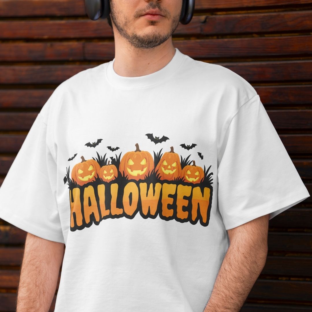 Back view of a person wearing a white t-shirt featuring a large Halloween pumpkin patch graphic with carved jack-o'-lanterns, grass, and bats.