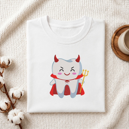 Folded white cotton t-shirt mockup featuring a cute devil tooth machine embroidery design, styled with cotton stems and a wooden cup   