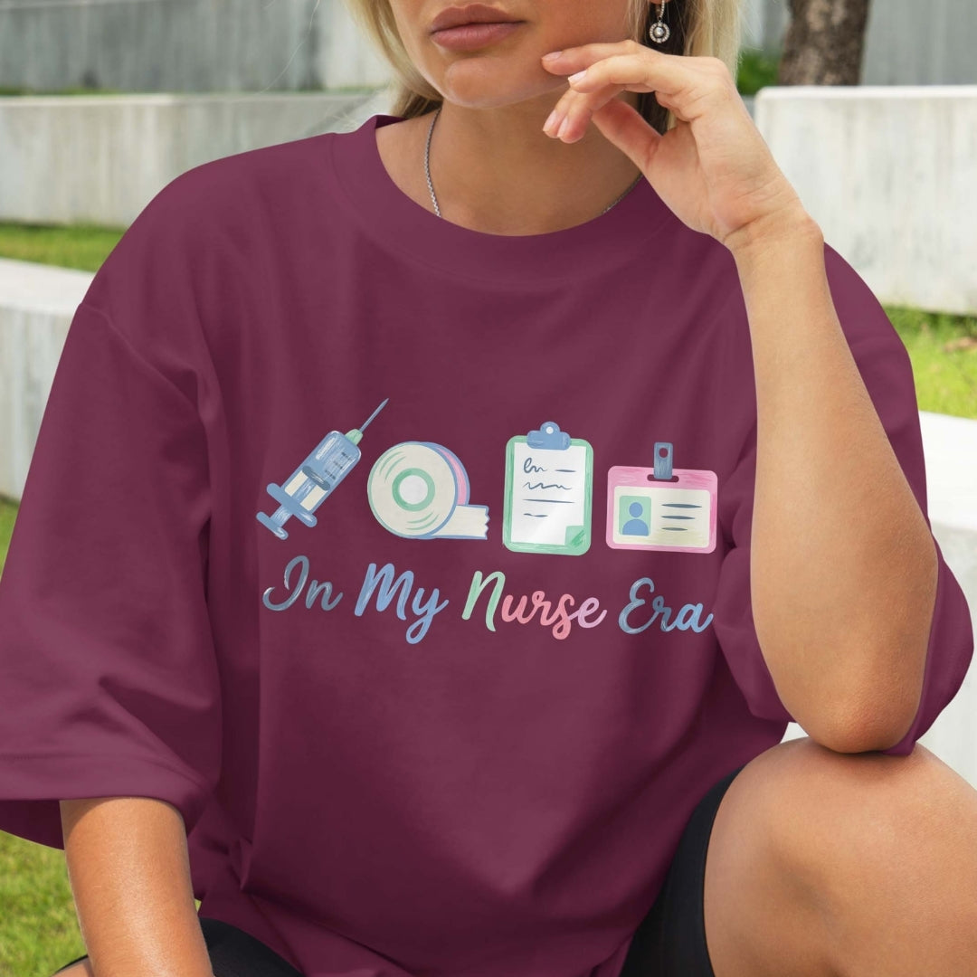 Person wearing a purple t-shirt with a nurse-themed design outdoors.
