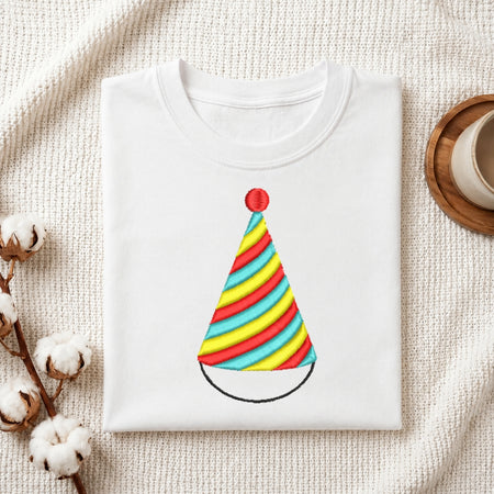 A white folded t-shirt featuring a colorful, spiral-striped party hat embroidery design.