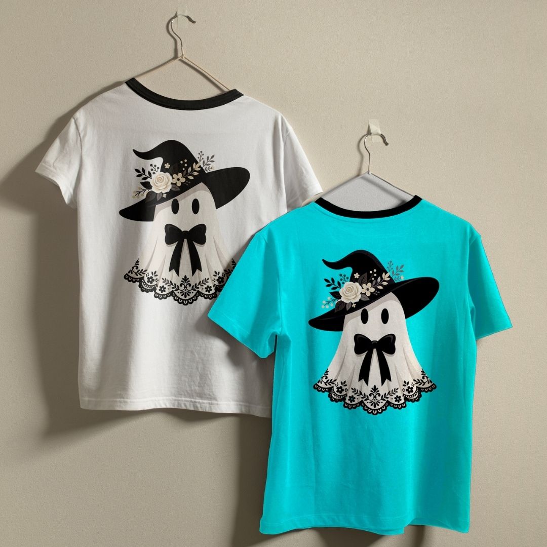 Person wearing a white t-shirt printed with a cute ghost wearing a black witch hat and a bow.
