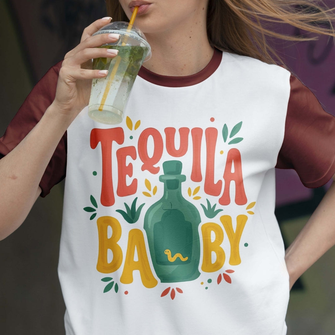 Person wearing a 'Tequila Baby' t-shirt and holding a drink.