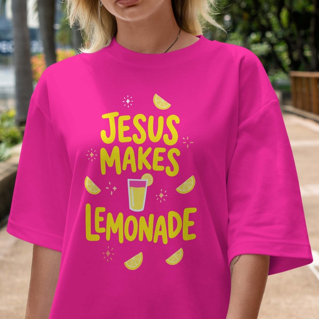 Person wearing a pink t-shirt with 'Jesus Makes Lemonade' text and graphics.