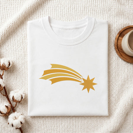 Folded white cotton t-shirt mockup featuring a golden starburst machine embroidery design, styled with cotton stems and a wooden cup