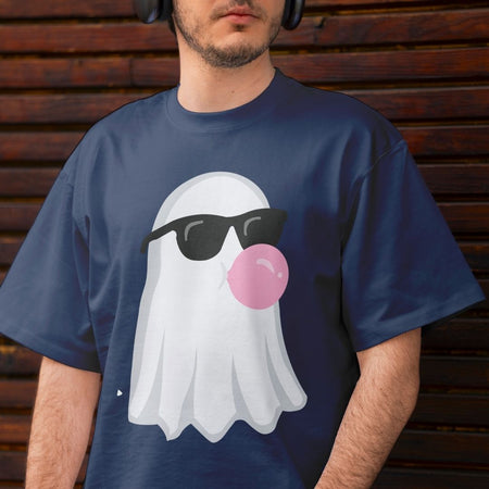 A man wearing a navy blue t-shirt with a graphic of a white ghost wearing black sunglasses and blowing a pink bubblegum bubble, set against a dark wooden background.