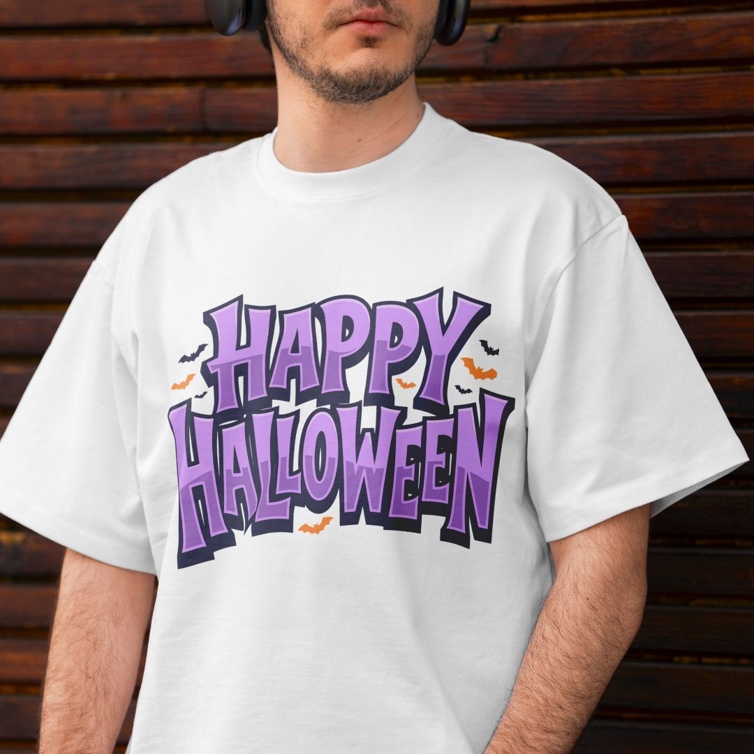 Man wearing an off-white t-shirt featuring a bold purple "Happy Halloween" graphic with bat details against a wooden background.