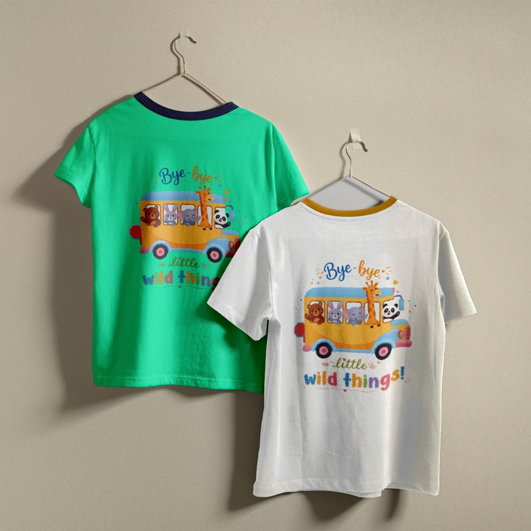 Two t-shirts hanging on hangers, one green and one white, both printed with a school bus graphic featuring cartoon animals and the text "Bye-bye little wild things!