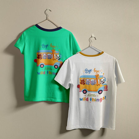 Two t-shirts hanging on hangers, one green and one white, both printed with a school bus graphic featuring cartoon animals and the text "Bye-bye little wild things!
