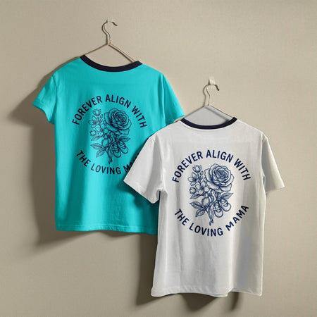 Two t-shirts hanging on a wall, one bright turquoise blue and one white, both featuring the circular retro "Forever Align with the Loving Mama" rose design.