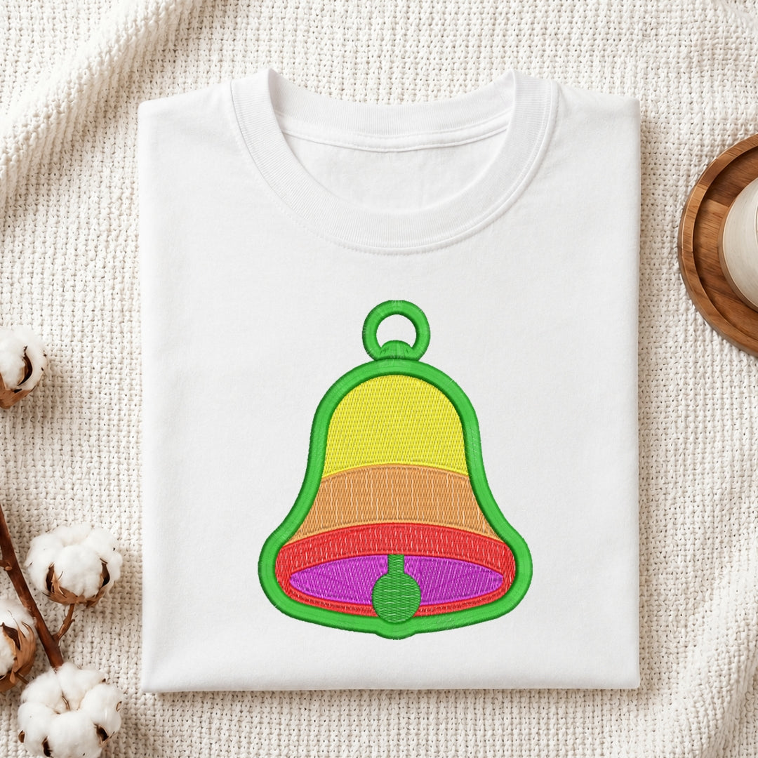 White sweatshirt with a colorful bell design on a textured surface.