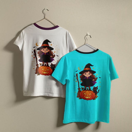 Two children's ringer t-shirts with a Halloween witch graphic, displayed on hangers against a beige wall. One shirt is white with a purple collar, and the other is turquoise with a black collar.