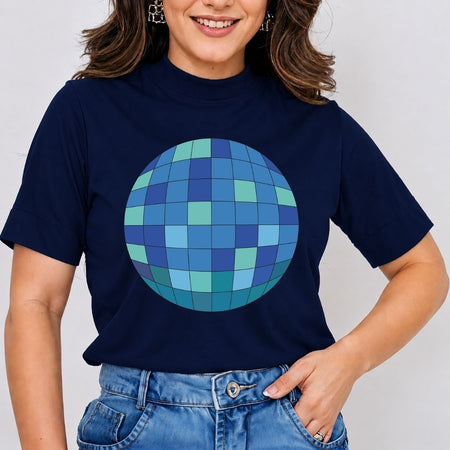 A woman wearing a navy blue short-sleeve t-shirt with a large blue and green mosaic disco ball graphic on the front, paired with blue jeans.