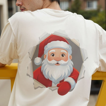 Person wearing a cream-colored t-shirt with a graphic of Santa Claus looking through a torn paper circle.