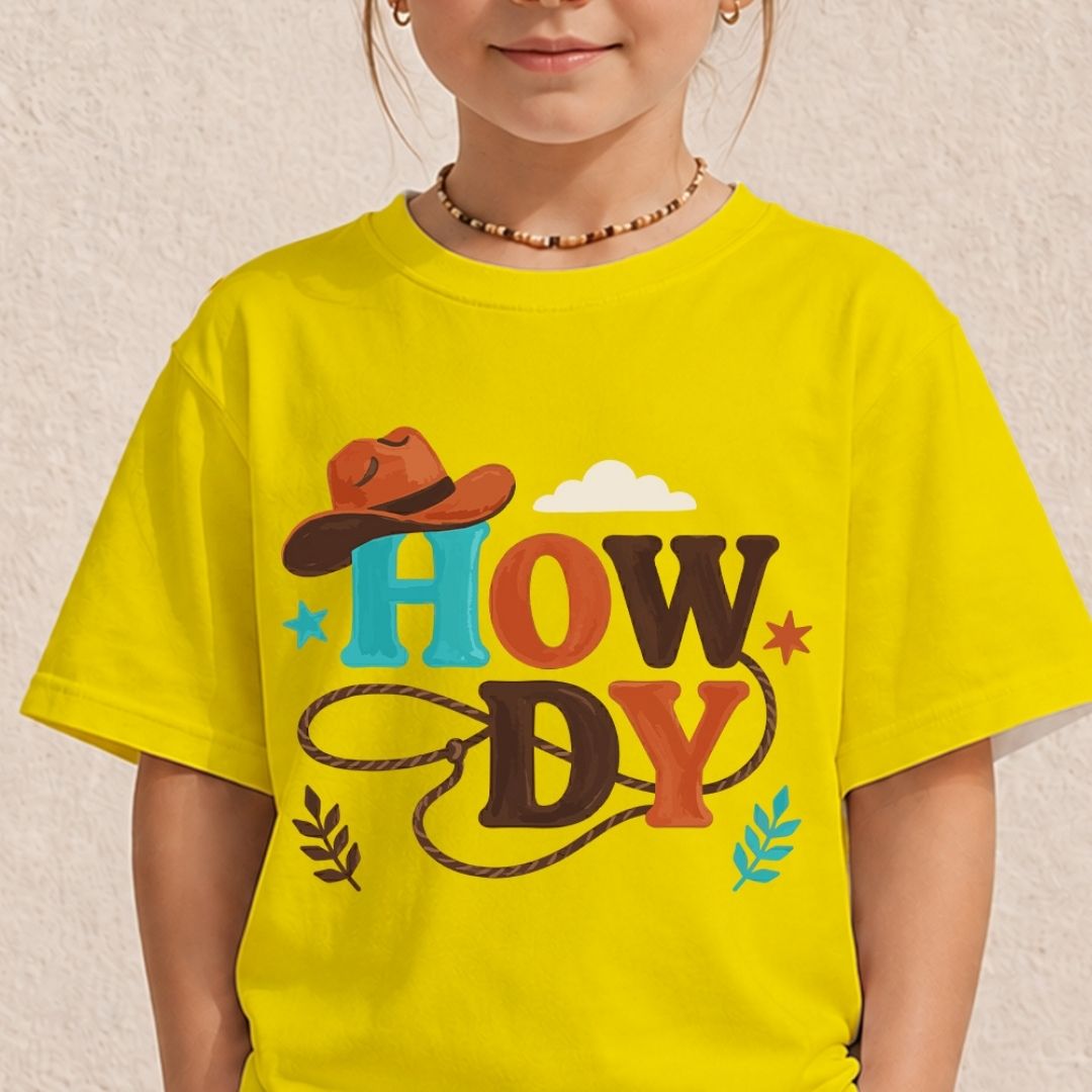 A young child wearing a bright yellow t-shirt displaying a colorful, vintage style "Howdy" block letter graphic with a cowboy hat on the front.