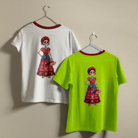 Two ringer t-shirts with red neck trims hanging on hangers against a beige wall. One shirt is white and the other is neon lime green, both featuring a colorful graphic of a Day of the Dead (Dia de los Muertos) woman on the back.