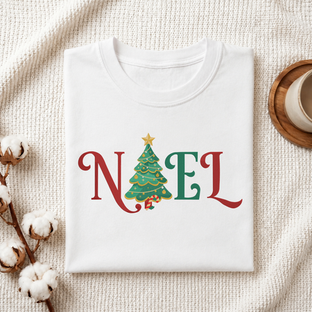 Folded white cotton t-shirt mockup featuring a "NOEL" Christmas tree machine embroidery design, styled with cotton stems and a wooden cup