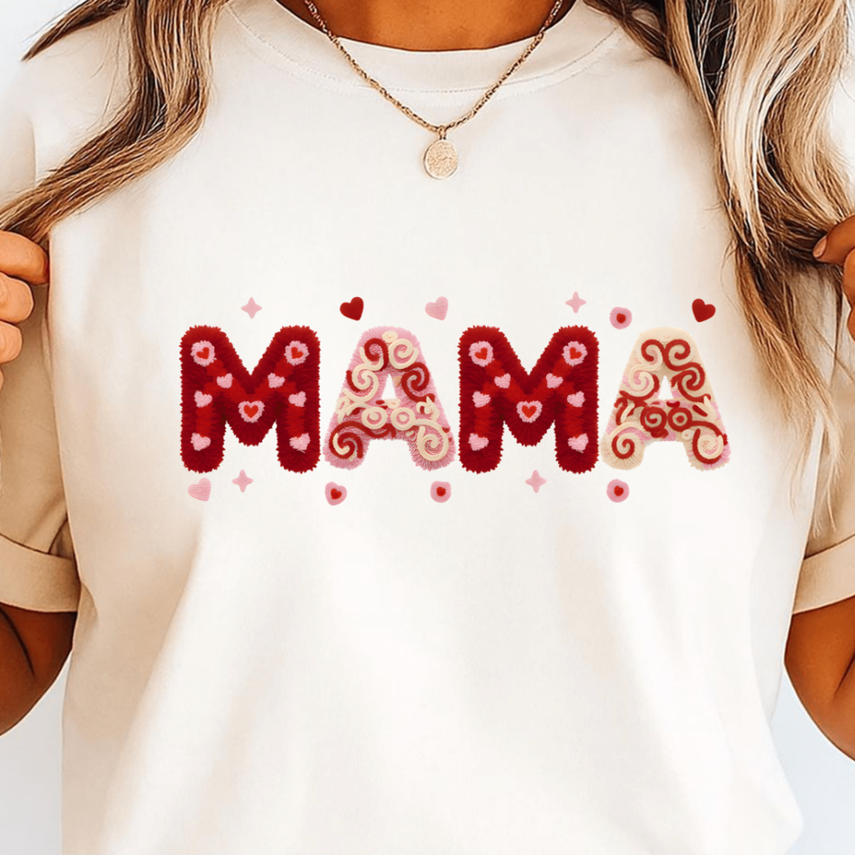 White t-shirt with 'MAMA' text in red and pink on a plain background