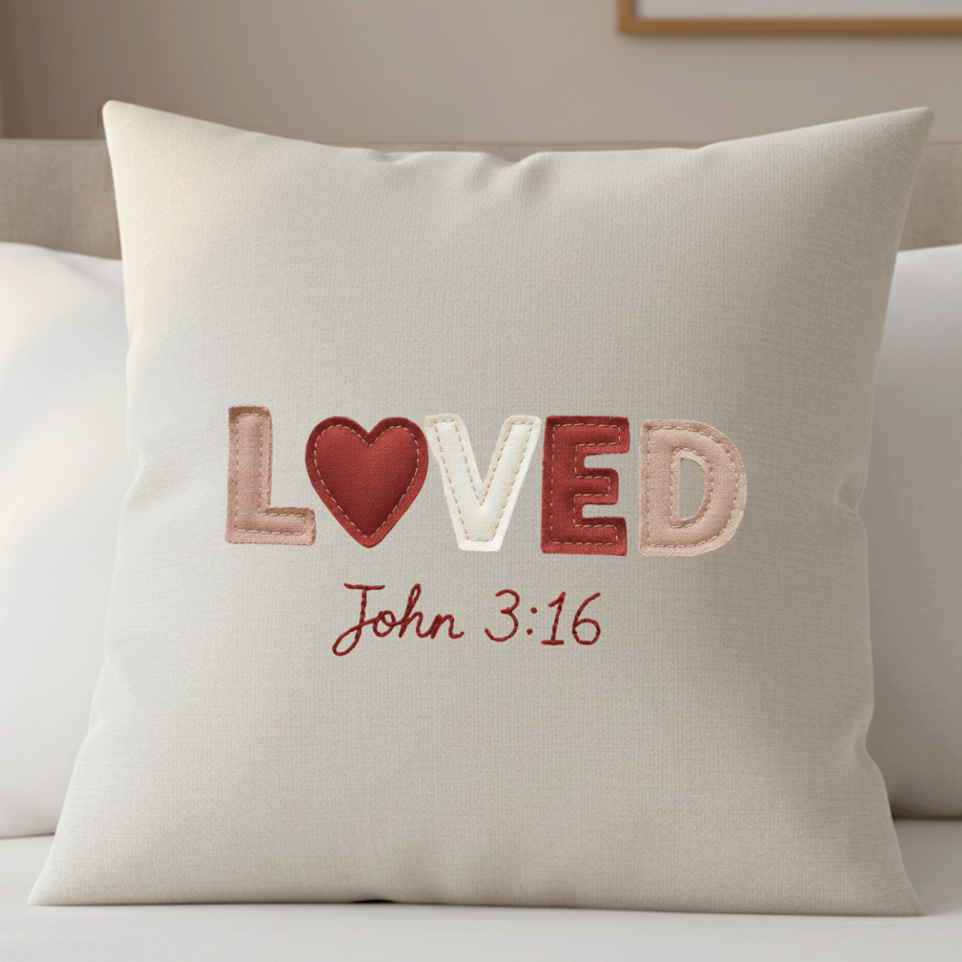 Decorative pillow with 'LOVED John 3:16' text on a neutral background