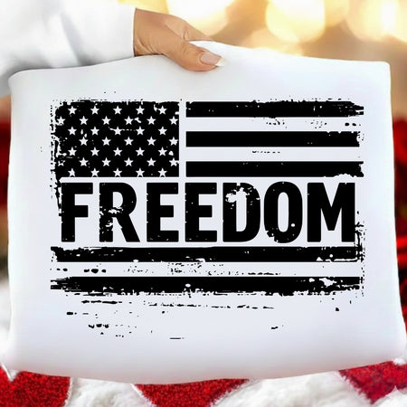 White pillow with American flag and 'FREEDOM' text held by a person against a blurred background