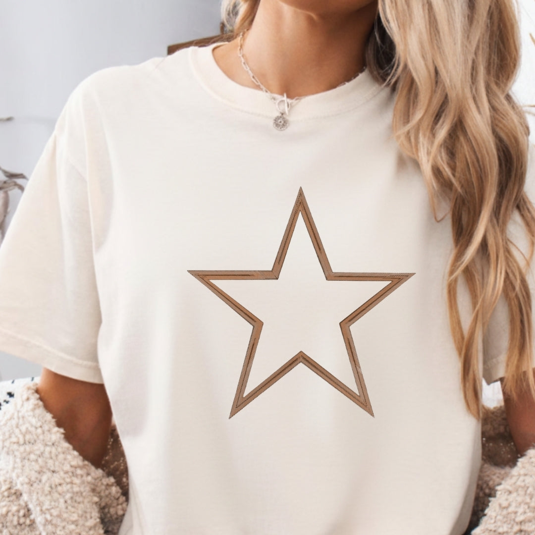 White t-shirt with a brown star design worn by a person with long blonde hair.