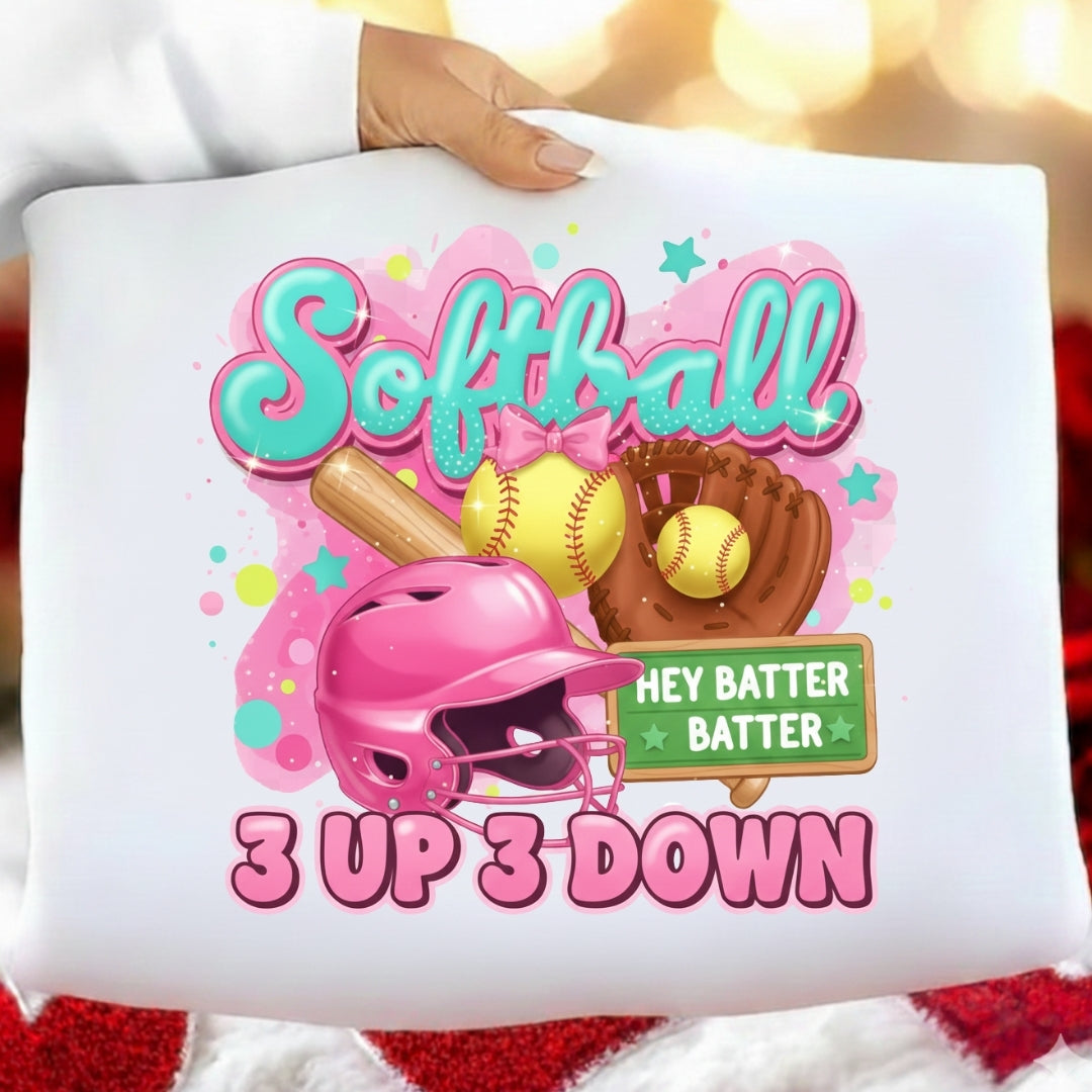 White pillow with colorful softball-themed design featuring a helmet, bat, and ball.