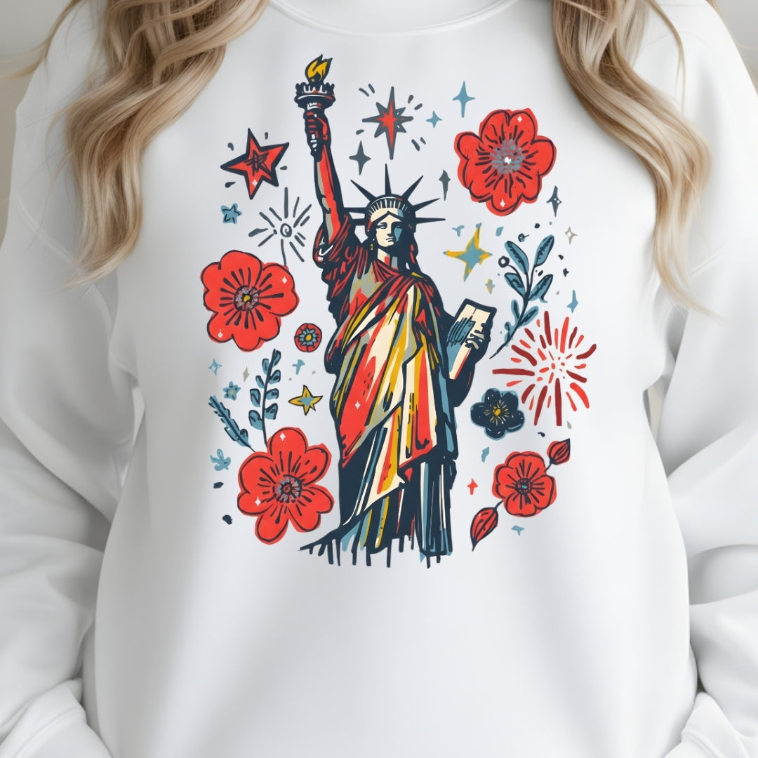 White sweatshirt with colorful design of the Statue of Liberty, flowers, and fireworks.