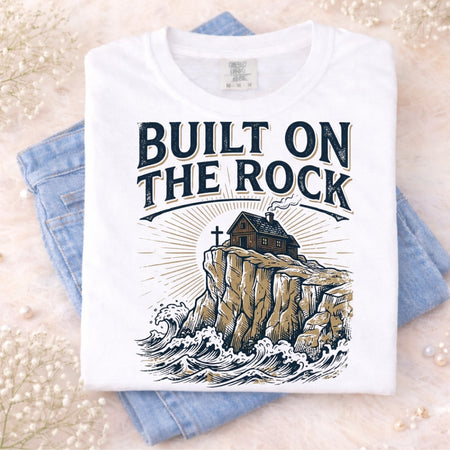 T-shirt with 'Built on the Rock' design on a light background