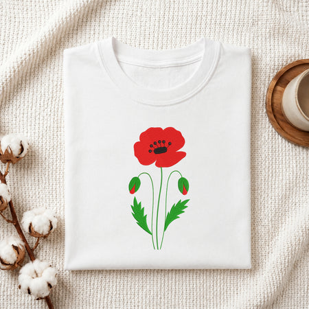 Folded white t-shirt featuring a red poppy flower embroidery design centered on the chest.