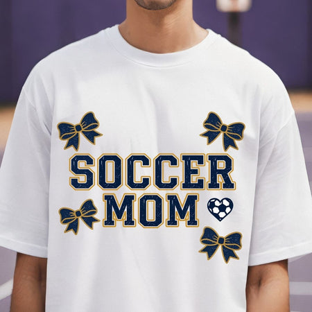 White t-shirt with 'Soccer Mom' text and decorative elements on a blurred background
