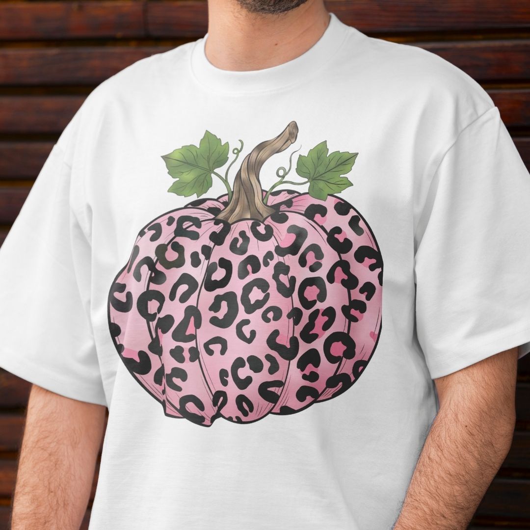 White t-shirt with a pink leopard print pumpkin design on a wooden background