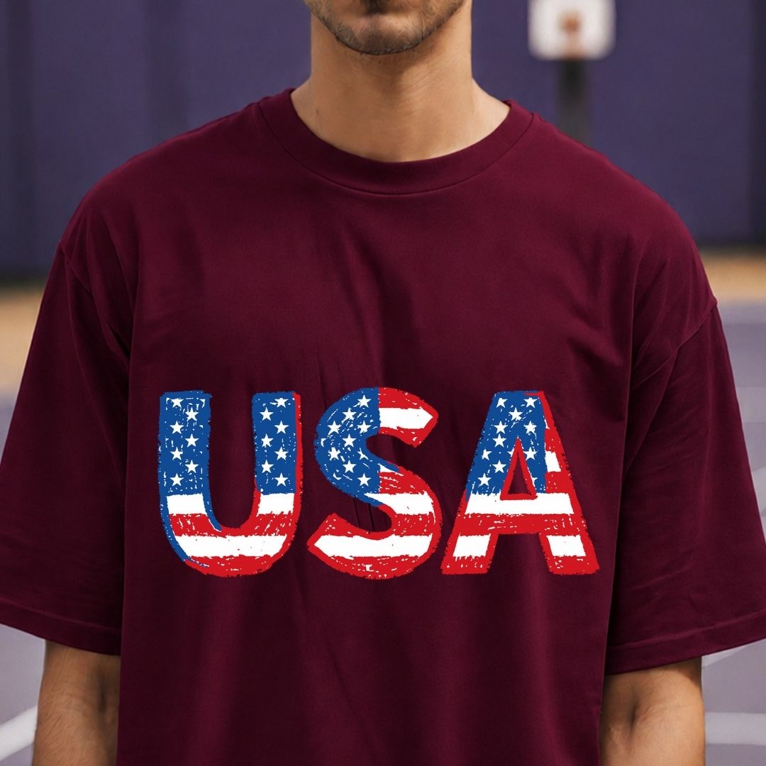 Person wearing a maroon t-shirt with 'USA' printed in American flag colors.