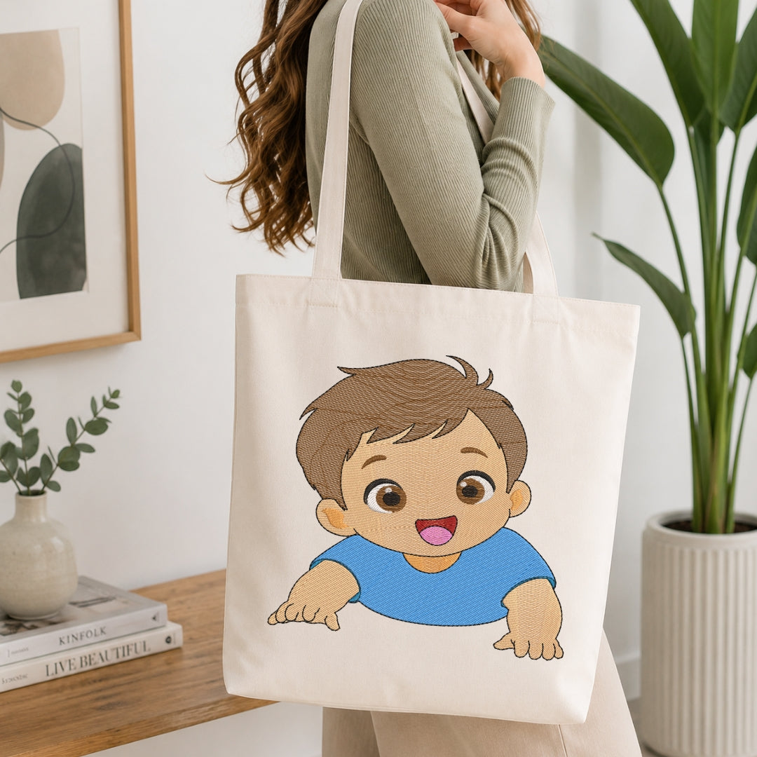A woman wearing a sage green ribbed long-sleeve top carries a cream canvas tote bag with a cartoon baby graphic. The baby graphic has brown hair, large brown eyes, and a blue shirt.