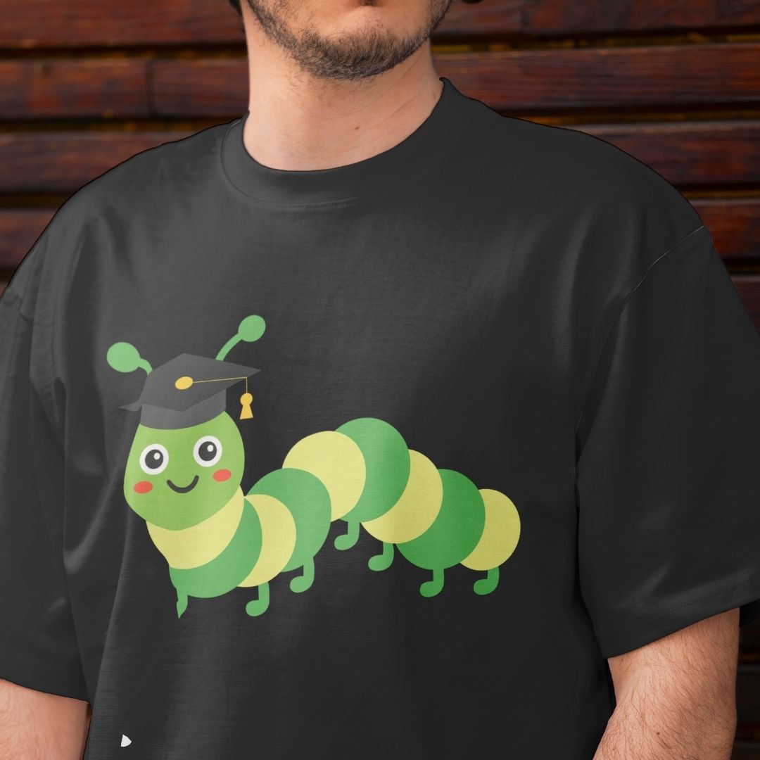 Black t-shirt with a cartoon caterpillar wearing a graduation cap on a wooden background
