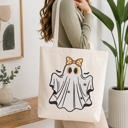Woman carrying a canvas tote bag decorated with a cute embroidered Halloween ghost.