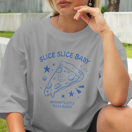 Person wearing a gray t-shirt with blue pizza-themed design outdoors.