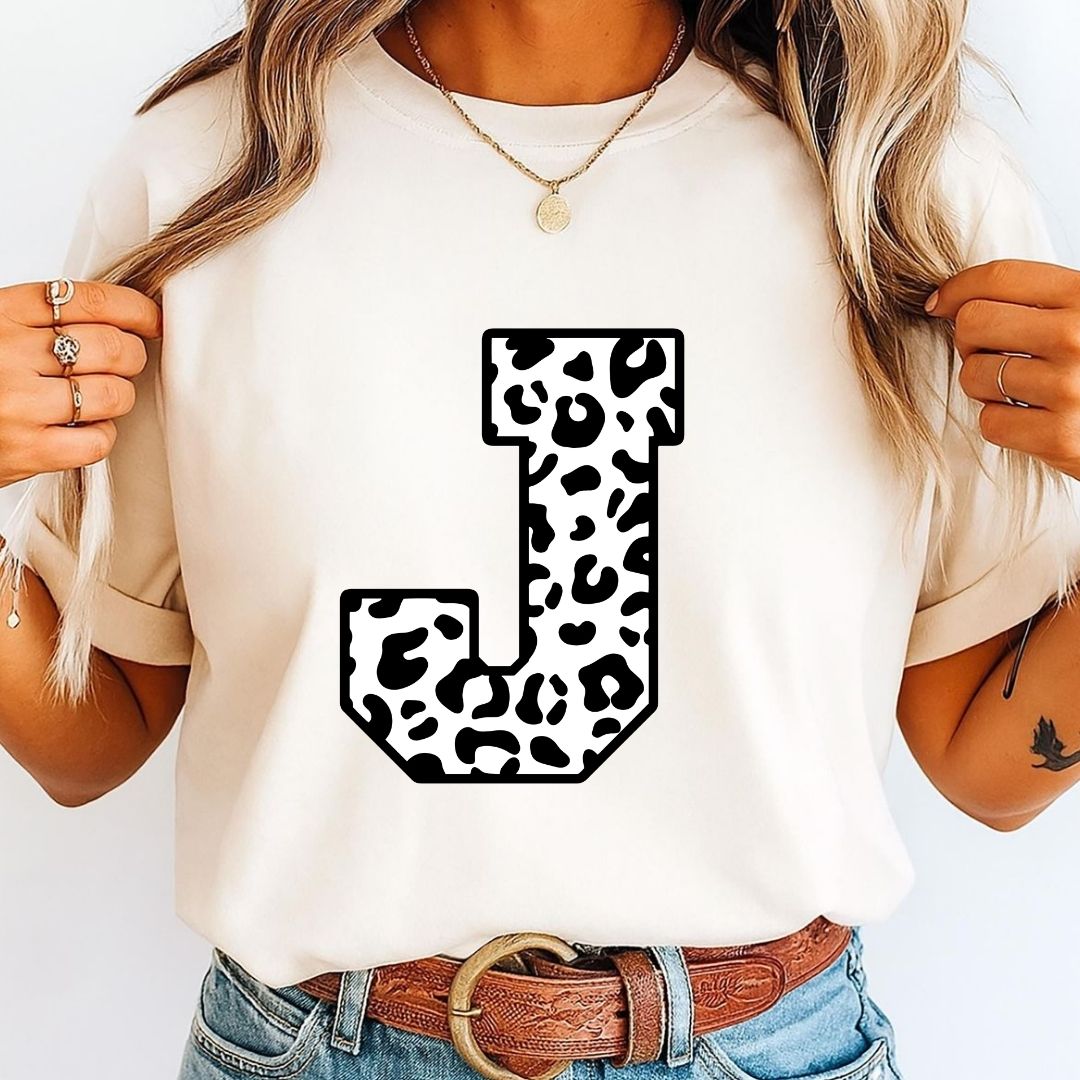 Person wearing a white t-shirt with a leopard print letter 'J' design.
