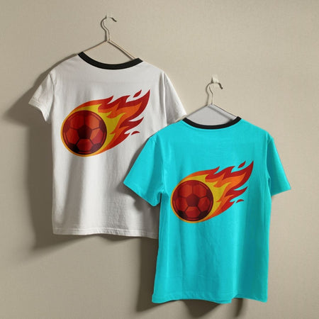 Two t-shirts, one white with black ringer trim and one bright cyan blue, hanging on a wall showing a matching graphic of a speed-trailing flaming soccer ball.