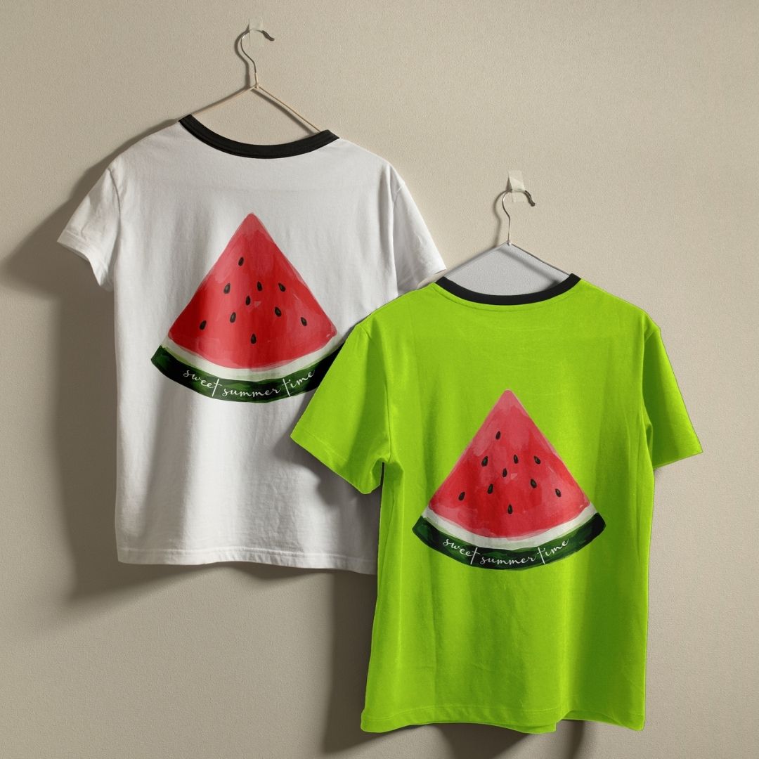 White and lime green ringer t-shirts with black collars hanging on a wall, showing the watermelon digital art design printed on apparel.