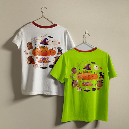 Two children's short-sleeve ringer T-shirts hanging on hangers against a plain beige wall. The left shirt is white with a red collar trim and a colorful Halloween graphic on the back featuring pumpkins, ghosts, bats, and witches.