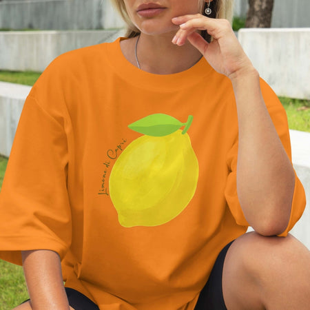 Person wearing an orange t-shirt with a lemon graphic outdoors