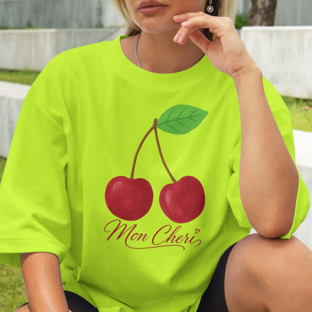 Person wearing a bright green t-shirt with cherry design and 'Mon Cheri' text.