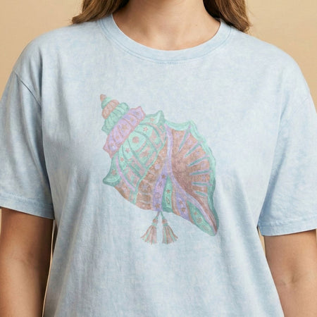 Light blue t-shirt with a colorful shell design on a beige background