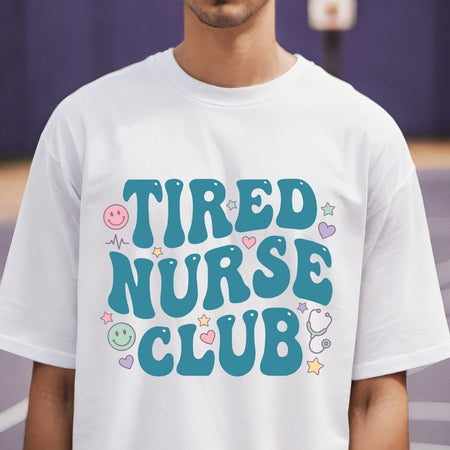 Person wearing a white t-shirt with 'TIRED NURSE CLUB' text and graphics.
