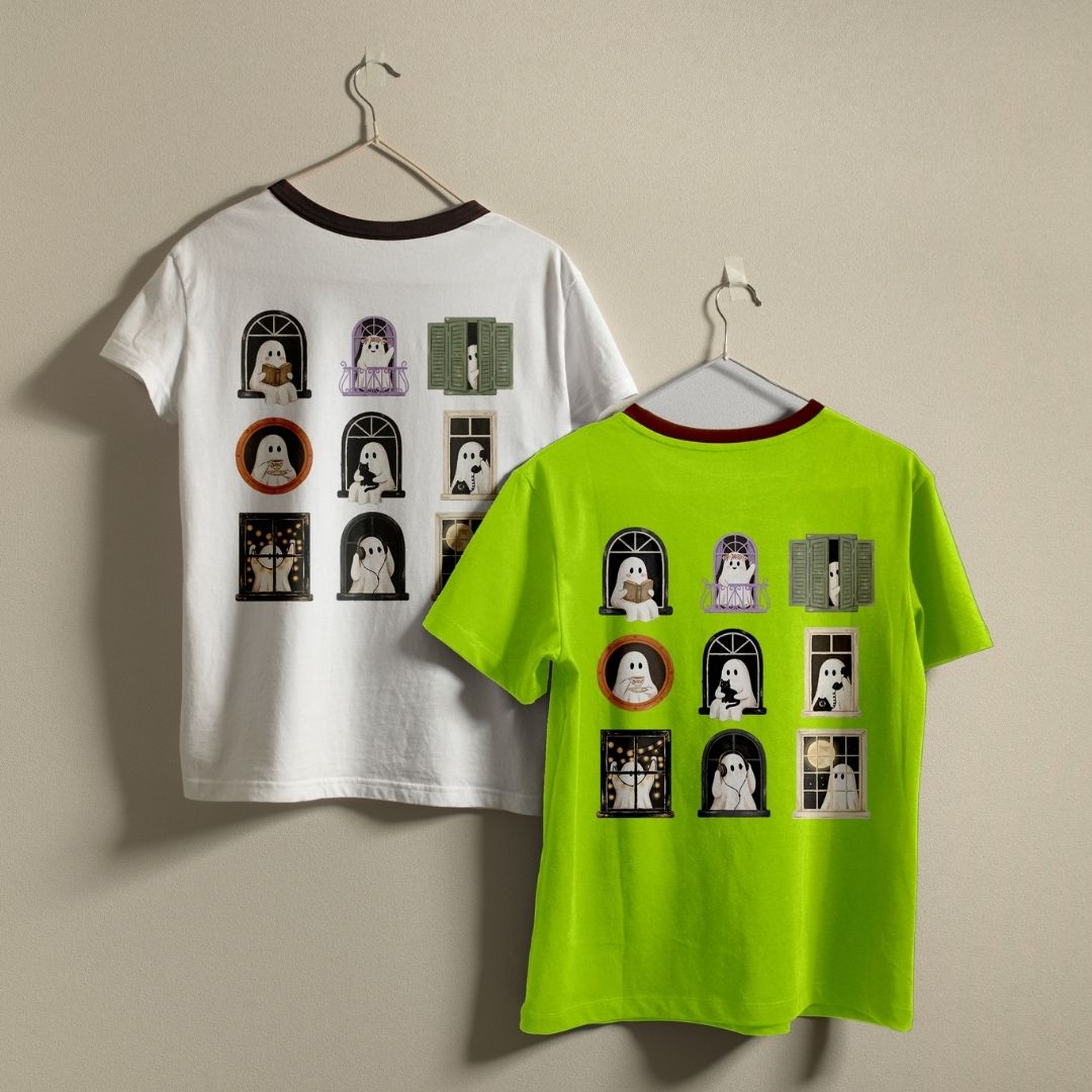 Two ringer t-shirts with a Halloween ghost graphic print, displayed on hangers against a plain beige wall. One shirt is white with a dark brown collar and sleeve cuffs, showing the back graphic.
