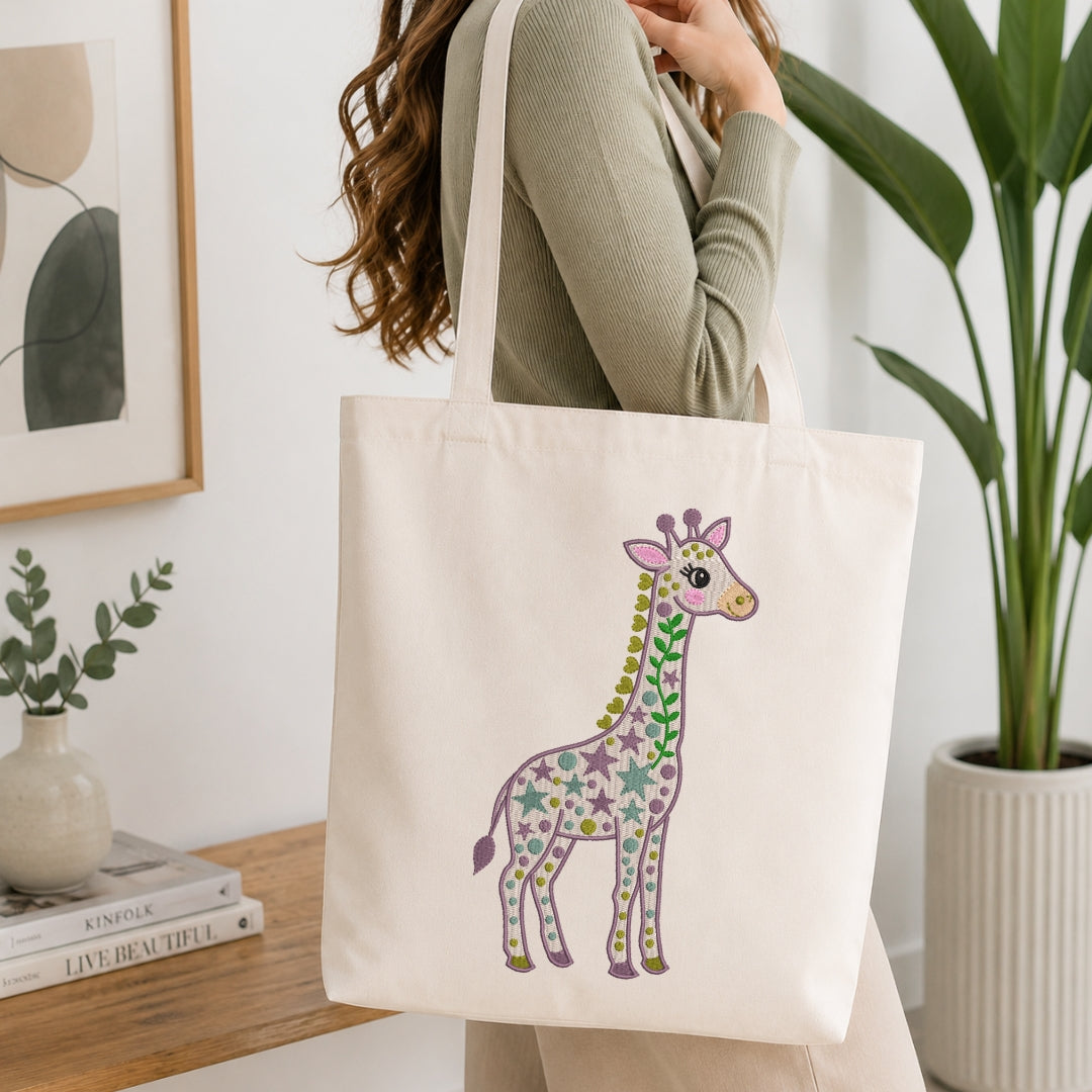 A woman wearing a sage green ribbed sweater carries a cream canvas tote bag with a colorful floral giraffe print, set in a bright, modern room with a wooden table and potted plants.
