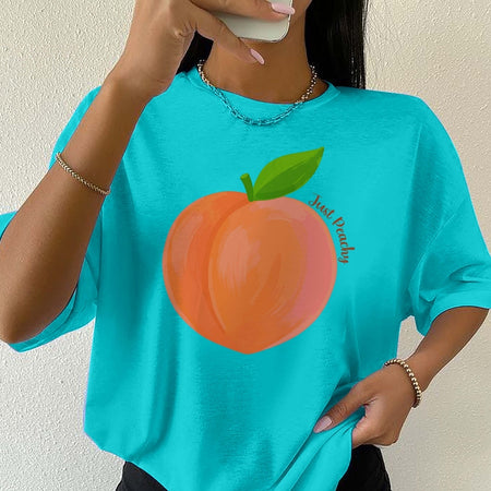 Person wearing a turquoise t-shirt with a peach graphic and text.