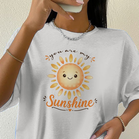 Person wearing a white t-shirt with a sun graphic and 'you are my sunshine' text.